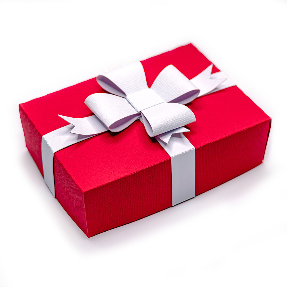 Red textured cardstock 3D gift box tied with a white paper ribbon and layered bow, shown closed a, a festive Christmas papercraft cut file for Silhouette Studio or alternate cutting software.